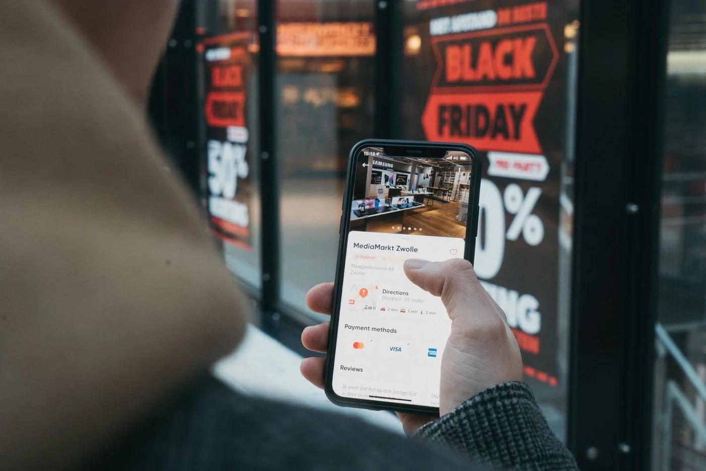 Someone looking at their phone for a sale while Black Friday shopping