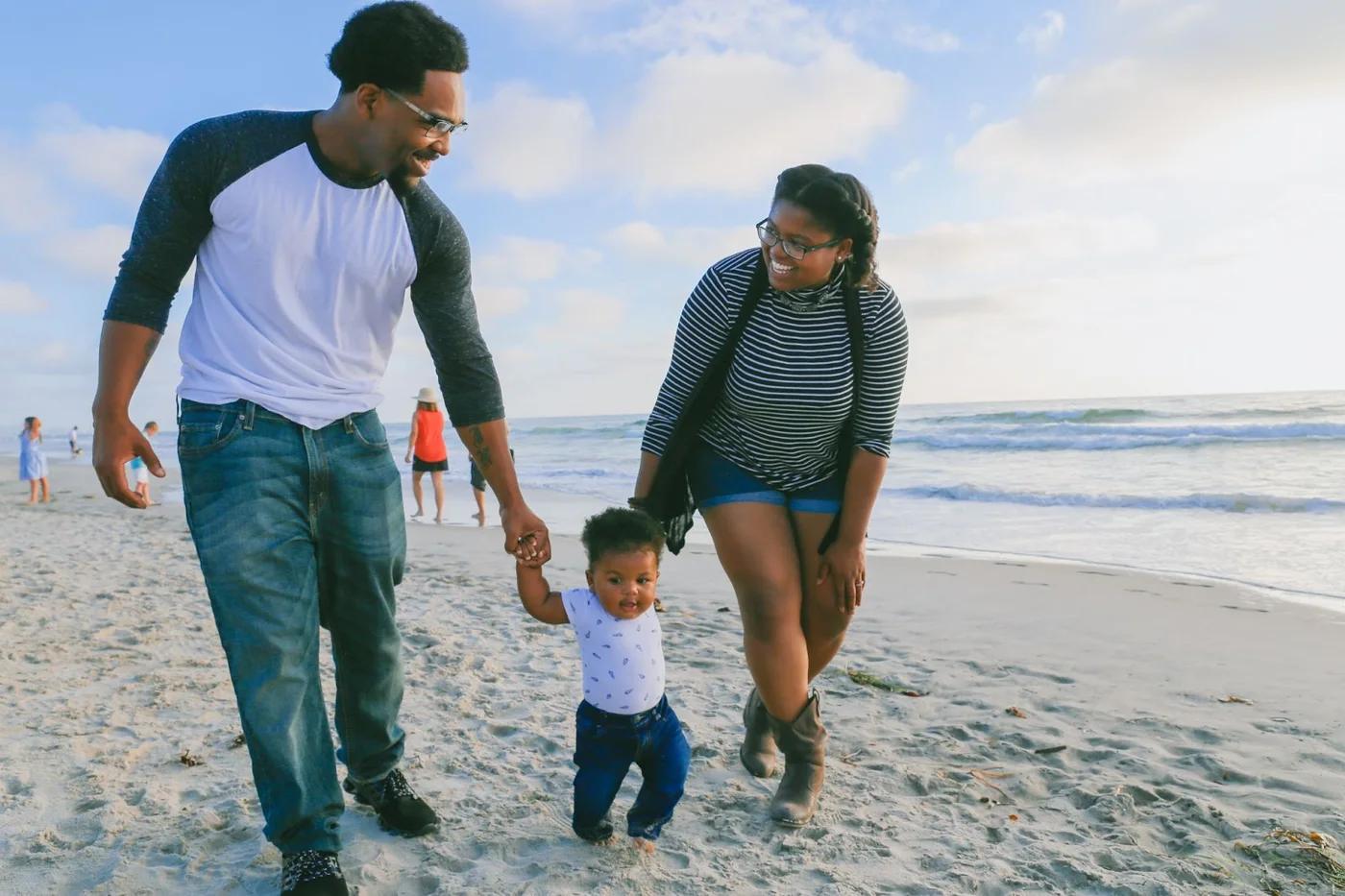 A family with their child walking along the beach