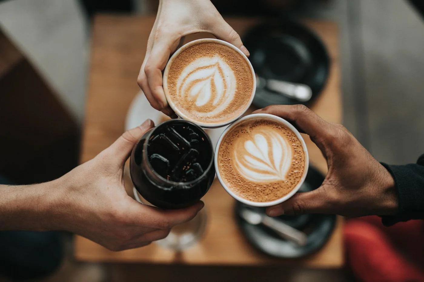 People clinking coffee mugs