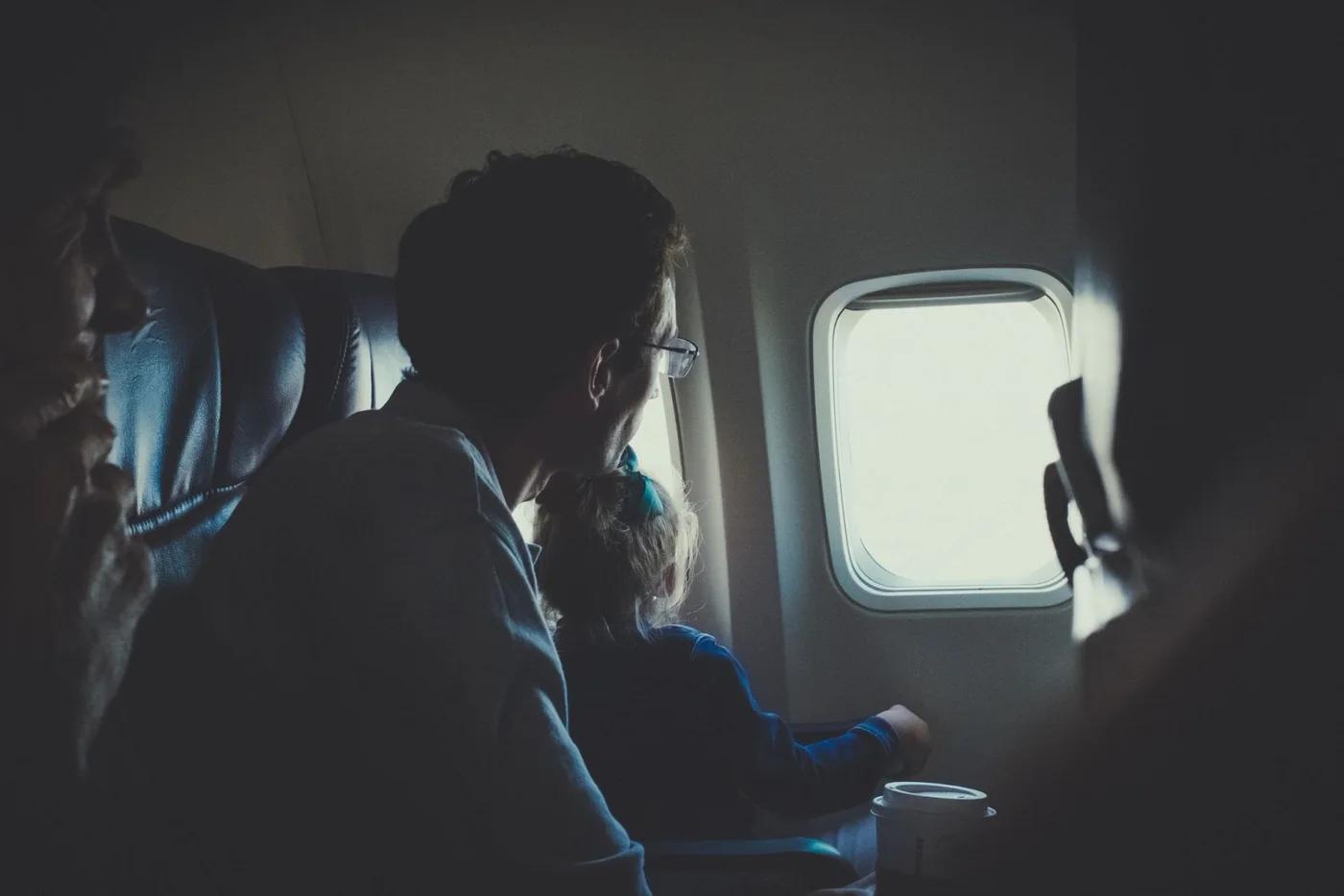 Father and daughter traveling on plane